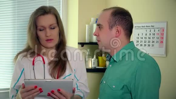 细心的女医生给病人看了数字平板电脑的男性化验结果视频的预览图