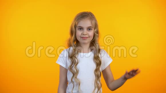 美丽的小女孩挥手问好微笑友好的相机快乐的童年视频的预览图