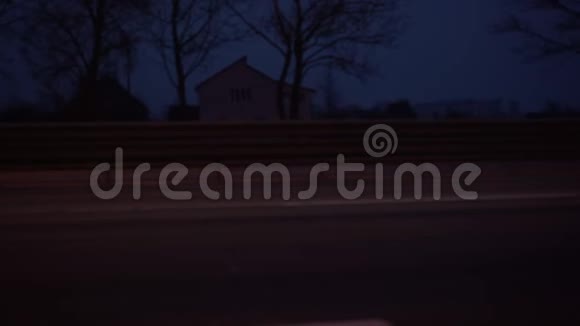 汽车在黄昏时分沿着农村地区的柏油路行驶视频的预览图