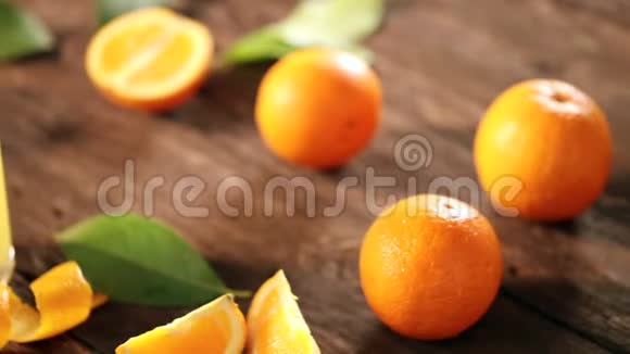 在木制背景下用玻璃切割橘子和果汁视频的预览图
