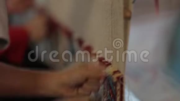 很少有女人缝地毯在织布机后面的特写镜头视频的预览图