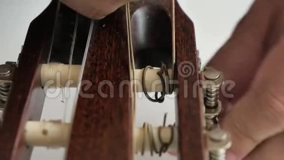 将人的手收起来取出并更换旧的尼龙吉他弦为古典吉他保持声学视频的预览图