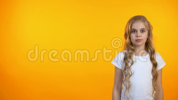 漂亮的女学生在橙色的背景上眨着眼睛小可爱模板视频的预览图