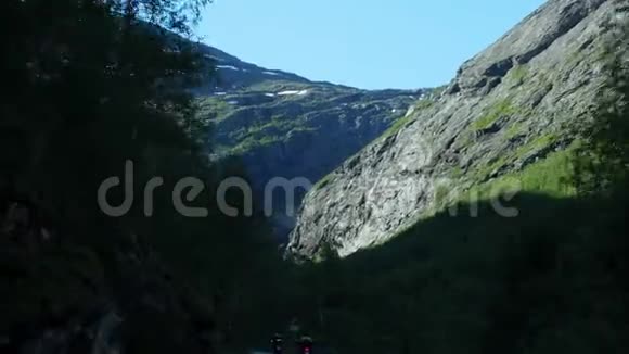 在挪威的山区和森林里开车从前挡风玻璃的角度看去特罗提根的路上的时间视频的预览图