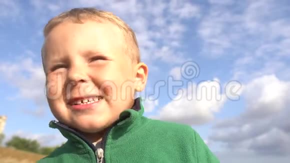 特写童童微笑着做鬼脸真实的情感天空中的男孩视频的预览图