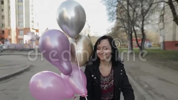 穿着氦气气球走在街上的漂亮女人视频的预览图
