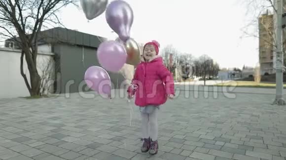 快乐的孩子带着氦气气球在街上跳跃视频的预览图