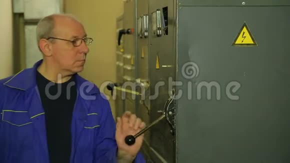 一名电工工程师举起手柄打开电气面板视频的预览图