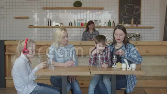 在自助餐厅与儿童会面的女性朋友视频的预览图