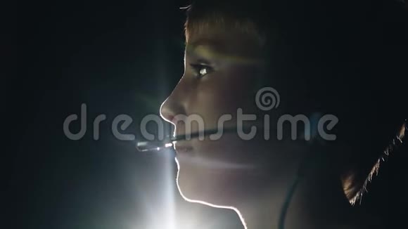 孩子坐在电视机前头上戴着耳机这个男孩玩电子游戏美丽的灯光视频的预览图