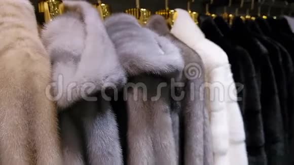 在一家零售时装商店的衣架上出售冬季出售的豪华貂皮大衣关门视频的预览图