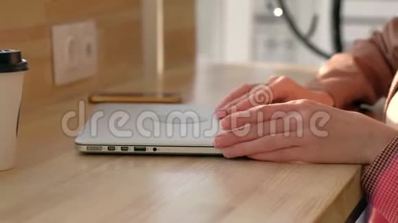 女人的手打开笔记本电脑在咖啡馆里键盘上打字特写镜头视频的预览图
