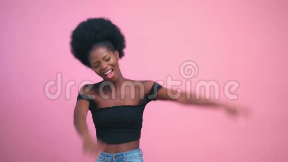 性感漂亮的美国黑人模特微笑着摆着粉红色的背景视频的预览图