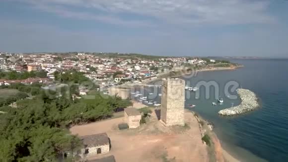 鸟瞰中世纪塔在NeaFokea海滩和一艘小船在港口Halkidiki希腊前进视频的预览图