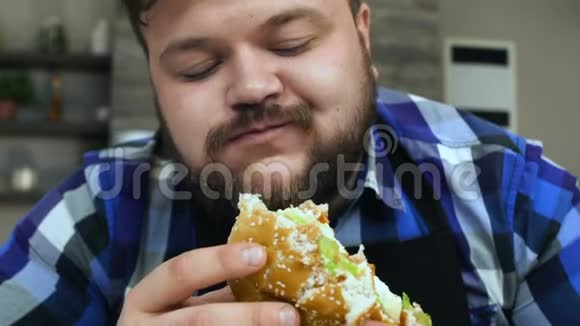 有胡子的胖子咬了一块汉堡包食物很好吃丰满的家伙很高兴不健康的生活方式视频的预览图