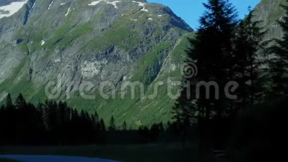 在挪威的山区和森林里开车从前挡风玻璃的角度看道路上的时间流逝视频的预览图