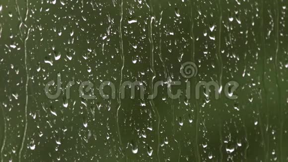 雨水从窗户表面往下流外面下着大雨强烈的风和雨滴落在b的玻璃窗上视频的预览图