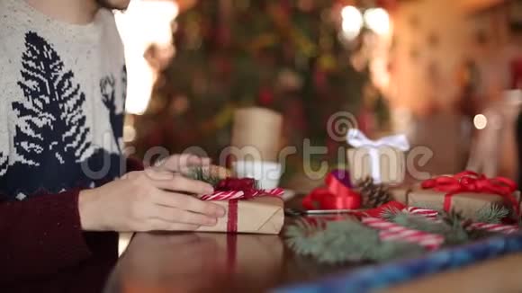 在圣诞礼物上人们的双手系着蝴蝶结近距离观看男性用纸包现在的盒子加上杉枝视频的预览图