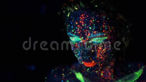 女孩在霓虹灯下的脸一位年轻女子的肖像用发光的颜料着色视频的预览图