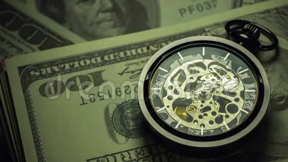 时光流逝的怀表美元钞票堆叠在黑暗中视频的预览图