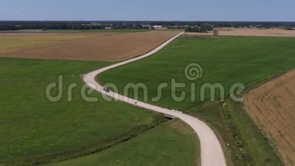夏季在美丽的白色砾石路上的农用拖拉机空中视频的预览图