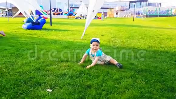 那孩子笨拙地走在一片绿油油的草地上跌倒了视频的预览图