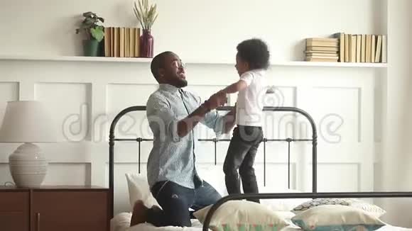 快乐的非洲父亲和儿子一起玩跳床视频的预览图