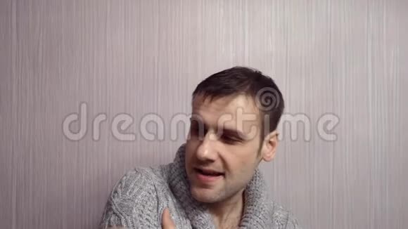 穿着灰色毛衣的男人冷得瑟瑟发抖在家上的背景下在家咳嗽视频的预览图