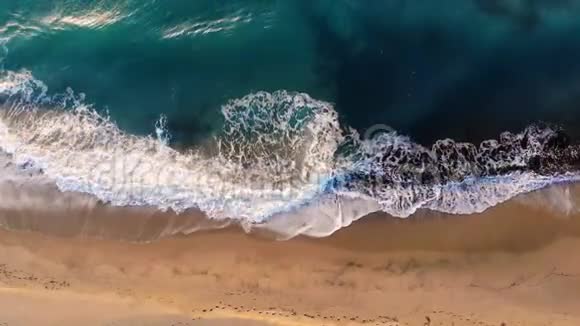 在绿松石蓝海面上的飞溅波的可观空中景色视频的预览图