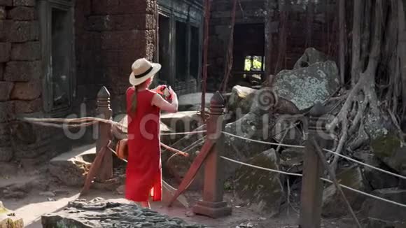 妇女拍摄塔普伦寺遗址和大石砖的照片视频的预览图