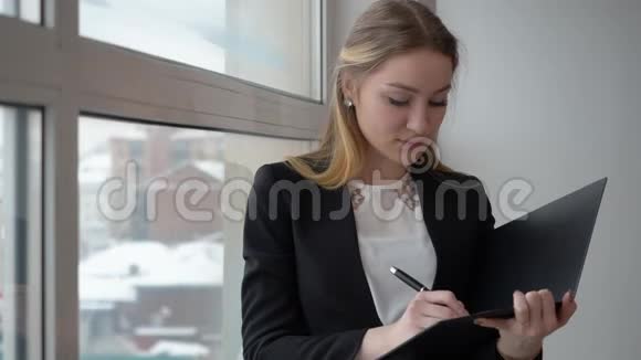 漂亮的企业家在她的文件上做笔记视频的预览图