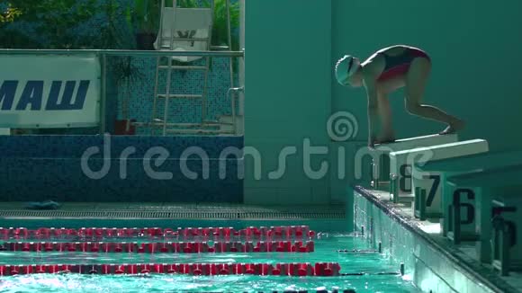 女子游泳运动员在深水中跳泳池慢动作女性专业游泳运动员潜水视频的预览图