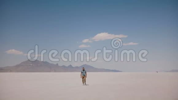 疲惫和疲惫的年轻人走向相机环顾美国犹他州史诗般炎热的阳光盐湖视频的预览图