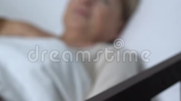 女人在病床上几乎没有呼吸按下求助按钮呼叫护士视频的预览图