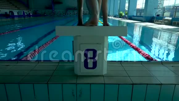 女子游泳运动员在深水中跳泳池慢动作女性专业游泳运动员潜水视频的预览图