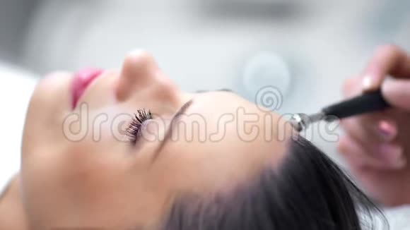专业美容师用现代设备制作微磨损美容程序的双手视频的预览图