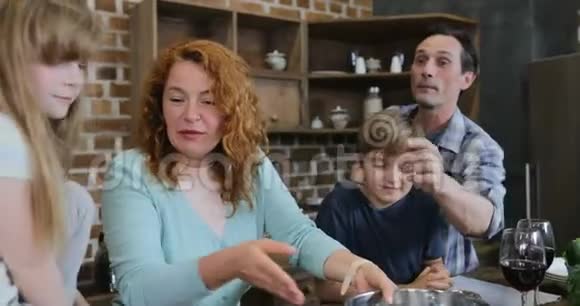 父母和孩子一起在家厨房做饭快乐的家庭在准备食物的时候在一起视频的预览图