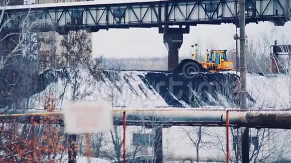 推土机将一堆煤洒在发电厂的地盘上煤被雪覆盖着视频的预览图
