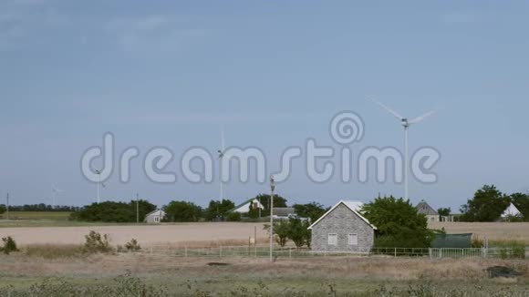 以巨大的风力涡轮机为背景的乡村住宅视频的预览图