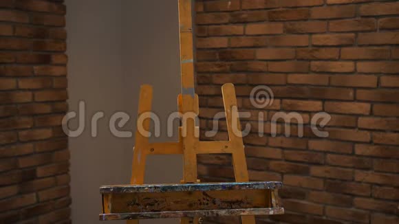 一个年轻的女人在画架上放一张画画布艺术工作室4K慢慢视频的预览图