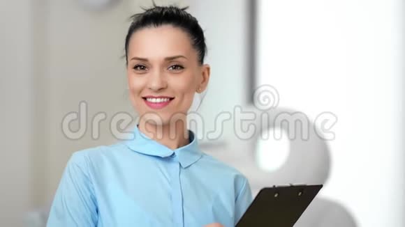 微笑的年轻女医生的肖像在现代诊所工作的乐趣中等特写视频的预览图