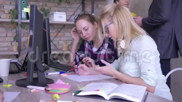 年轻女性同事在办公室解决问题和讨论工作相关事项视频的预览图