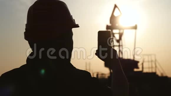 石油钻井平台上的工程师用智能手机拍照石油行业采用手机通讯视频的预览图