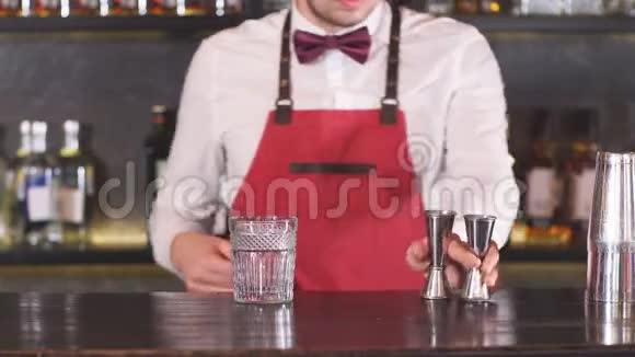 酒保将冰屑放入餐厅柜台的空鸡尾酒杯中视频的预览图