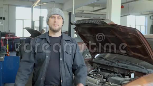 汽车修理店里摆着两条手臂交叉站立的机械师画像视频的预览图