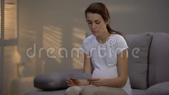 沮丧的女士撕裂超声图像和哭泣意外怀孕视频的预览图