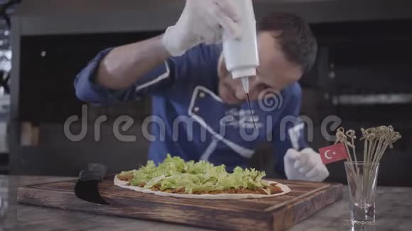 熟练的厨师制服准备美味的盘子包裹在拉瓦什白色橡胶手套厨师倒生菜叶视频的预览图
