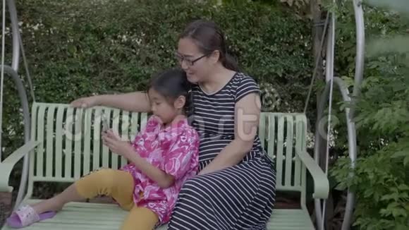 亚洲家庭带着智能手机在户外摇摆视频的预览图