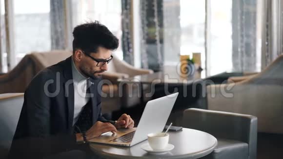 公司经理午餐休息时使用现代笔记本电脑在咖啡馆工作视频的预览图