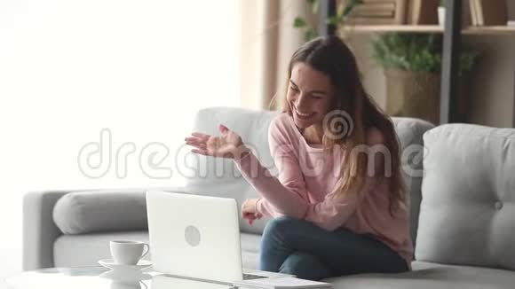 快乐的年轻女子挥舞着双手在笔记本电脑上打视频电话视频的预览图